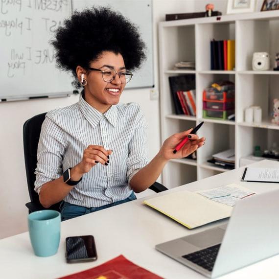 Young adult sitting at an office desk taking an online class